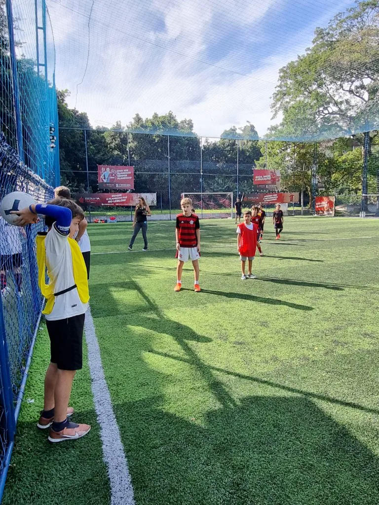 Crianças jogando futebol no campo durante festa de aniversário na Arena Society Show, no Leblon