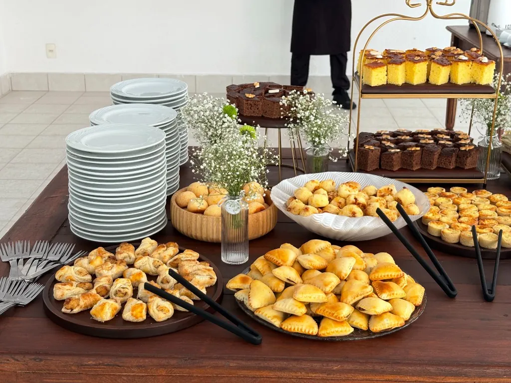 Mesa de finger food com salgados, pães de queijo e bolos em evento da Buffet Show no Rio de Janeiro