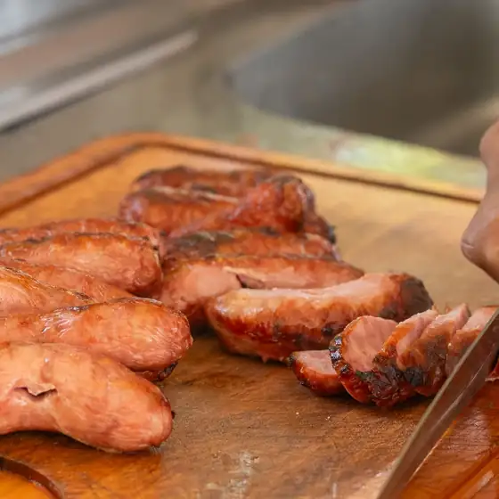 Linguiça grelhada sendo fatiada em evento da ChurrascoShow no Rio de Janeiro